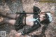 A woman laying on the ground holding a sword.