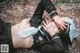A woman laying on the ground with her hands on her head.