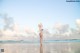 A woman in a bikini standing on a beach.