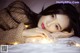 A woman laying on top of a bed covered in lights.