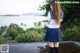 A woman in a school uniform standing on a balcony.