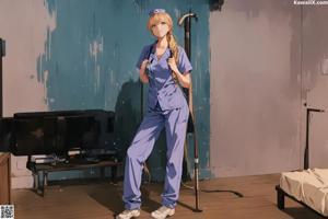 A woman in a blue uniform standing in a room.