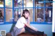 A woman sitting on top of a bench holding a book.